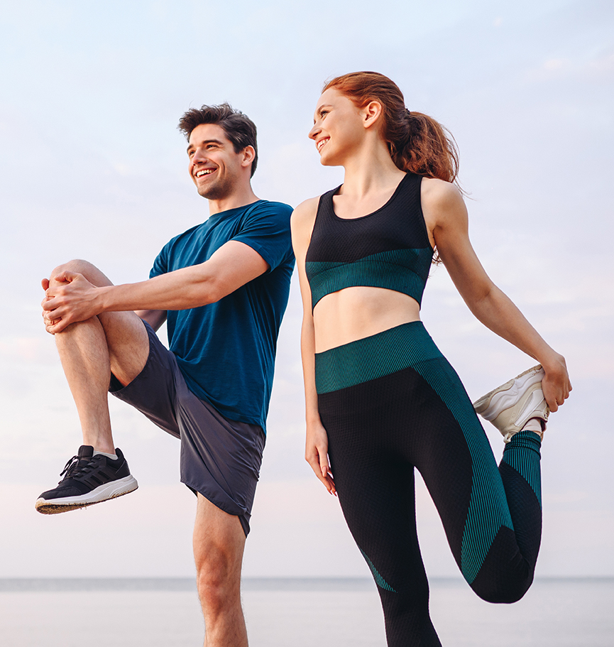 Lower couple young two friend strong sporty sportswoman sportsman woman man in sport clothes warm up training do stretch exercise on sand sea ocean beach outdoor jog on seaside in summer day morning. Escale évasion